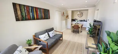 a living room with a couch and a table at Sea 'n Summit Suite in Hermanus