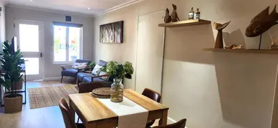 a living room with a dining room table and chairs at Sea 'n Summit Suite in Hermanus