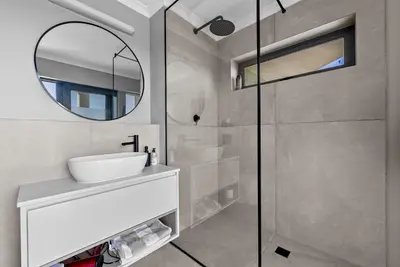 a bathroom with a sink and a mirror at ocean12 Guesthouse Sunset Beach in Cape Town