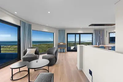 a living room with two chairs and a table at ocean12 Guesthouse Sunset Beach in Cape Town
