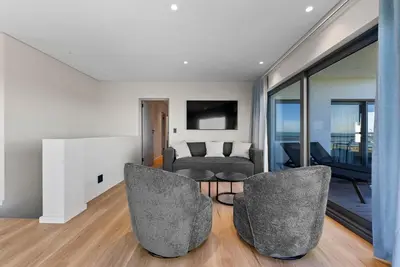 a living room with two chairs and a couch at ocean12 Guesthouse Sunset Beach in Cape Town