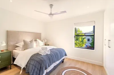 a bedroom with a bed with a ceiling fan at Tram Vibes in Franschhoek
