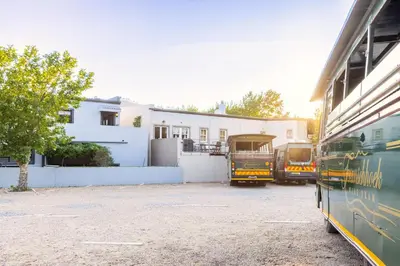 three buses parked in a parking lot in front of a building at Tram Vibes in Franschhoek