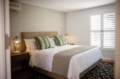 a bedroom with a large bed and a window at One on Main in Franschhoek