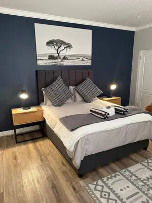 a bedroom with a large bed with two night stands at Yellow Wood 1 in Hermanus