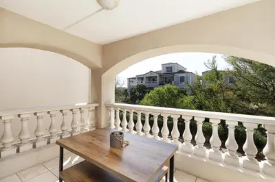 a balcony with a wooden table and two windows at Dorphene 204 in Cape Town