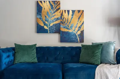 a blue couch in a living room with two paintings at Dorphene 204 in Cape Town