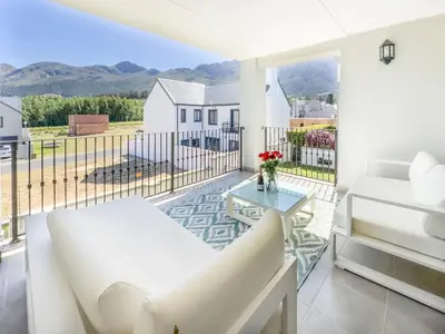 a living room with a white couch and a glass table at Tre Jolie in Franschhoek