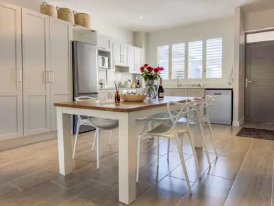 a kitchen with a table with chairs and a refrigerator at Tre Jolie in Franschhoek