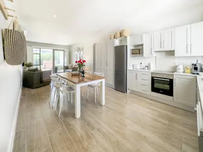 a kitchen with a table with chairs and a refrigerator at Tre Jolie in Franschhoek
