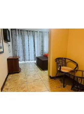 a living room with a chair and a table at Lookout Star Legend Accommodation in Parow