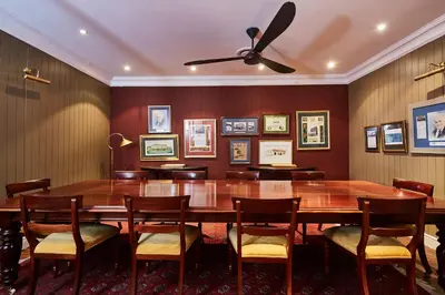 a dining room with a large wooden table and chairs at The Devon Valley Hotel in Stellenbosch