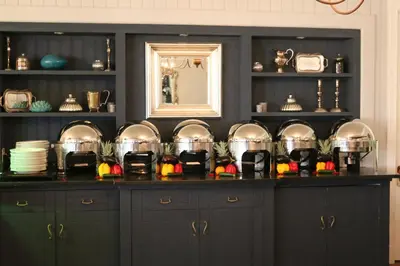 a kitchen with black cabinets and a mirror at The Devon Valley Hotel in Stellenbosch