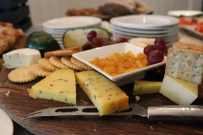 a plate of cheese and crackers and fruit and vegetables at The Devon Valley Hotel in Stellenbosch