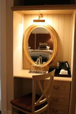 a mirror on a desk with a chair in a room at The Devon Valley Hotel in Stellenbosch