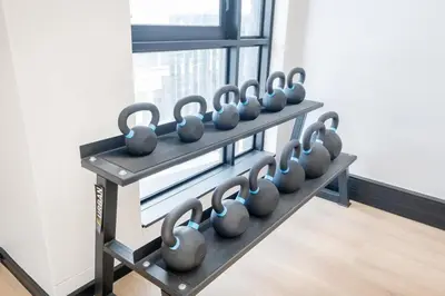 a row of dumbbells on a shelf in a gym at 715 Riverlands - Lux 2 Bedroom Apartment in Cape Town