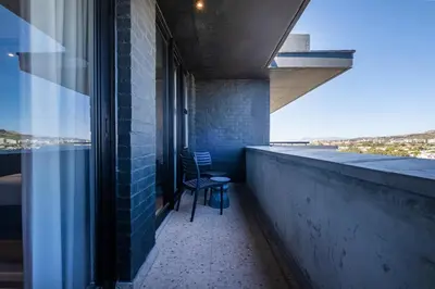a chair sitting on the balcony of a building at 715 Riverlands - Lux 2 Bedroom Apartment in Cape Town