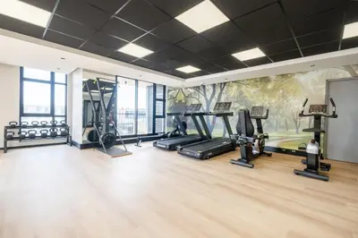 a gym with treadmills ellipticals and a mural at 715 Riverlands - Lux 2 Bedroom Apartment in Cape Town