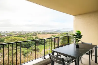 a balcony with a table and chairs and a view at Belina - Waters Edge Premier in Cape Town