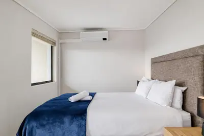 a bedroom with a large white bed and a window at Belina - Waters Edge Premier in Cape Town