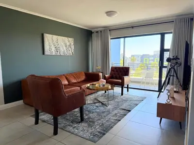 a living room with a couch and a table at Elegant Two Bedroom Apartment in Century City in Cape Town