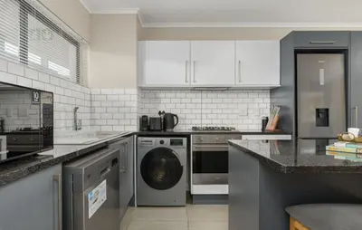 a kitchen with a washer and a dishwasher at Elegant Two Bedroom Apartment in Century City in Cape Town