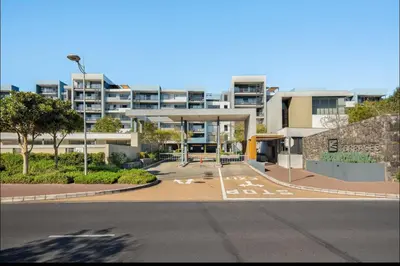 an empty parking lot in front of a building at Elegant Two Bedroom Apartment in Century City in Cape Town
