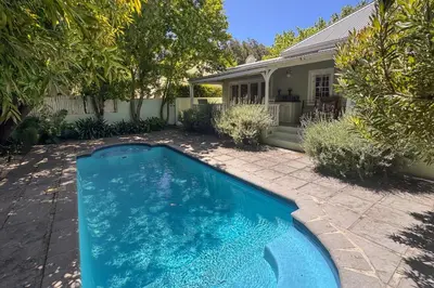 a swimming pool in the yard of a house at La Petite Maison in Franschhoek