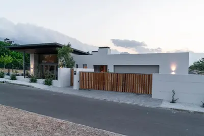 a white house with a fence on the side of a road at 6 on Heide in Franschhoek
