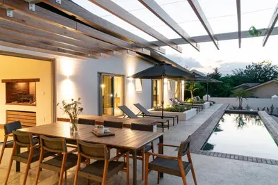 a patio with a table and chairs next to a pool at 6 on Heide in Franschhoek