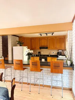 a kitchen with wooden cabinets and a white refrigerator at Nimara de So in Gordonʼs Bay