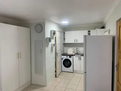 a kitchen with a refrigerator and a washing machine at GRACE self-catering apartments in Goodwood
