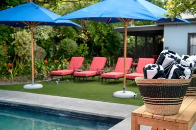 a group of chairs and umbrellas next to a pool at La Fontaine Boutique Hotel by The Oyster Collection in Franschhoek