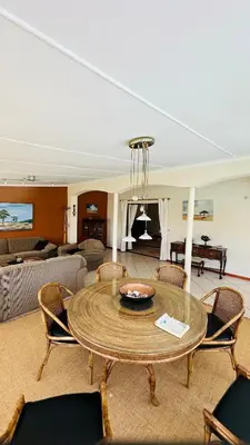 a living room with a table and chairs at Kleine Villa mit Pool und freie Sicht auf die Berge in Somerset West