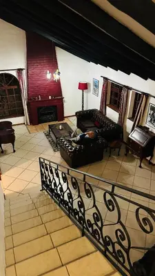 a living room with couches and a fireplace at Kleine Villa mit Pool und freie Sicht auf die Berge in Somerset West