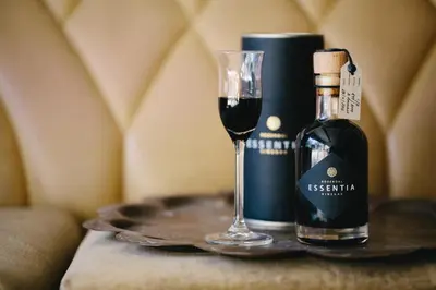 a bottle of wine and a glass on a table at Rozendal Stay in Stellenbosch