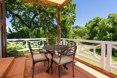 a patio with a table and chairs on a deck at Rozendal Stay in Stellenbosch
