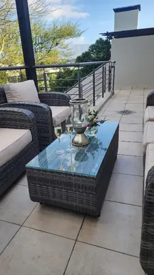 a table with two glasses of wine on a patio at Water side Town house on the canal in Cape Town