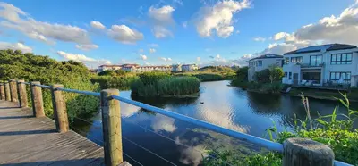 a bridge over a river with houses and buildings at Water side Town house on the canal in Cape Town