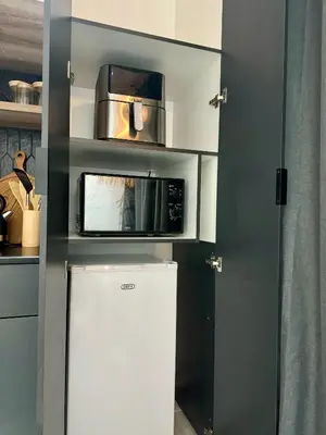 a small kitchen with a microwave and a refrigerator at Little Heaven in Cape Town