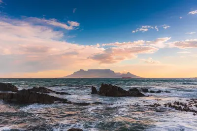 a view of the ocean with a mountain in the background at Ocean View Apartment in Blouberg Beachfront in Cape Town