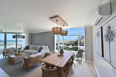 a living room with a table and a couch at 3 Bedroom Cabana on the Beach in Cape Town