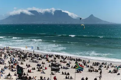 a crowd of people on a beach with the ocean at Studio Kiters Room - Dolphin Beach in Cape Town