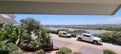 two cars parked in a parking lot next to a river at Studio Kiters Room - Dolphin Beach in Cape Town