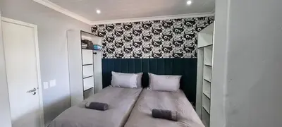 a small bedroom with a bed with two pillows at Studio Kiters Room - Dolphin Beach in Cape Town