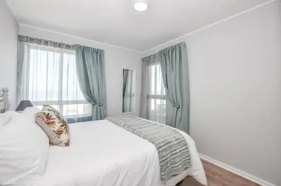 a bedroom with a white bed and a window at 3 Bedroom Apartment - Stunning Ocean Views in Cape Town
