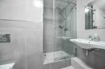 a white bathroom with a sink and a shower at 3 Bedroom Apartment - Stunning Ocean Views in Cape Town