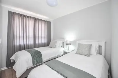 a bedroom with two beds and a window at 3 Bedroom Apartment - Stunning Ocean Views in Cape Town