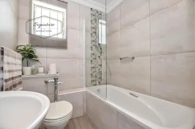 a bathroom with a tub and a toilet and a sink at 2 Bedroom Apartment - Zeezicht Blouberg in Cape Town