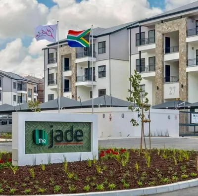 a sign in front of a building with two flags at Luxury Apartment in Somerset West in Strand
